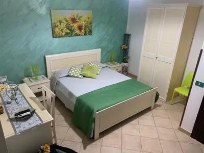 a bedroom with a bed and a table and a desk at B&B Poliglotta in Castelluzzo