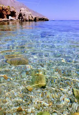 a rocky shore with rocks and the water at B&B Poliglotta in Castelluzzo
