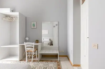 a white room with a table and a chair at GuestHost - Stazione Notarbartolo Bright & Cozy Apartment in Palermo
