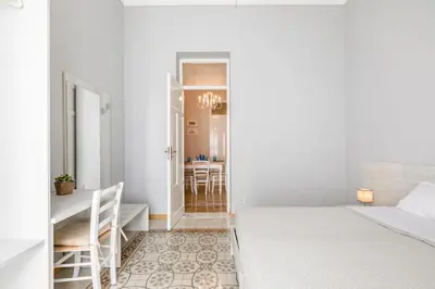 a white bedroom with a bed and a desk at GuestHost - Stazione Notarbartolo Bright & Cozy Apartment in Palermo