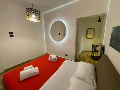 a room with a red and white bed and a mirror at BB4U Apartments al Massimo in Palermo