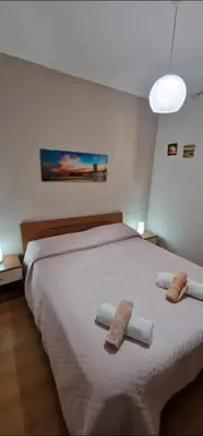 a bedroom with a large white bed with towels on it at Charming house with sea and mountain views in Alcamo in Alcamo