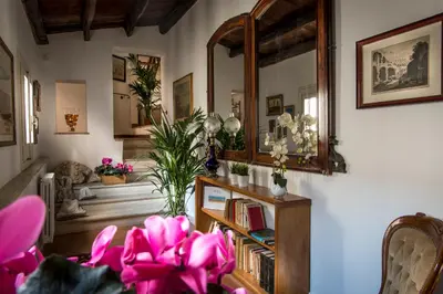 a living room with pink flowers and a mirror at Residence Torremuzza - Charming House In The Heart Of Palermo with lovely view in Palermo