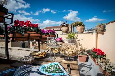 a table with food and wine glasses on a balcony at Residence Torremuzza - Charming House In The Heart Of Palermo with lovely view in Palermo