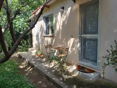 a patio with a table and chairs next to a window at Camera indipendente con bagno immersa nel verde in Bagheria