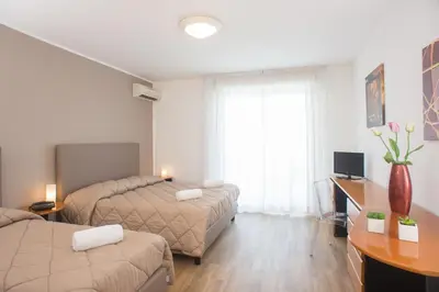 a hotel room with two beds and a desk at Hotel Bel 3 in Palermo