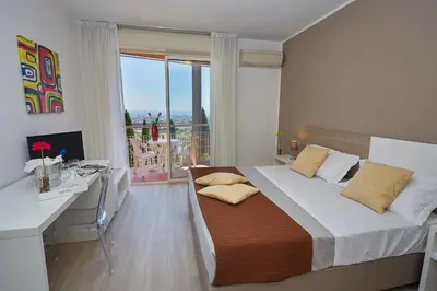 a bedroom with a bed and a desk and a window at Hotel Bel 3 in Palermo
