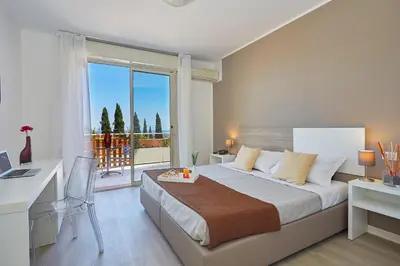 a bedroom with a bed with a desk and a window at Hotel Bel 3 in Palermo