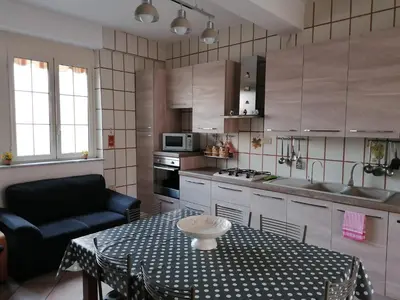 a small kitchen with a table and a couch at Le stanze di Anna in Capaci