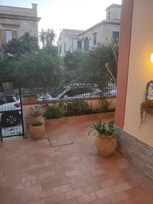 a patio with two potted plants and a fence at La casetta della Letizia in Mondello