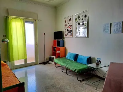a living room with a green couch and a window at La casa sull'albero in Palermo