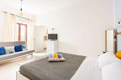 a white bedroom with a large bed with a pillow at La Boucherie in Palermo