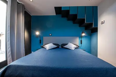 a blue bedroom with a blue bed with a staircase at MONTESANTO36 APARTMENTS in Palermo