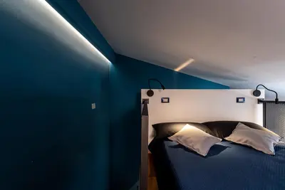 a bedroom with a bed with a blue wall at MONTESANTO36 APARTMENTS in Palermo