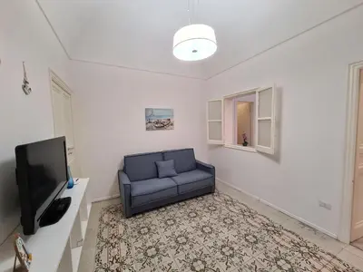 a living room with a blue couch and a tv at Casa Lara in Castellammare del Golfo