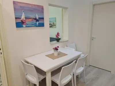 a white dining room with a white table and chairs at Casa Lara in Castellammare del Golfo