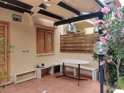 a table and bench in a room with flowers at Makari mare in Macari