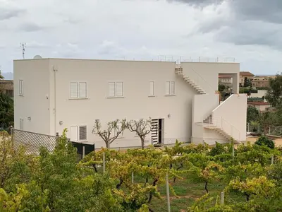a white building with a staircase in front of it at Villa Bouganville - charming sea ​​view- 160 mq in Alcamo
