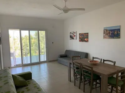 a living room with a wooden table and chairs at Villa Bouganville - charming sea ​​view- 160 mq in Alcamo