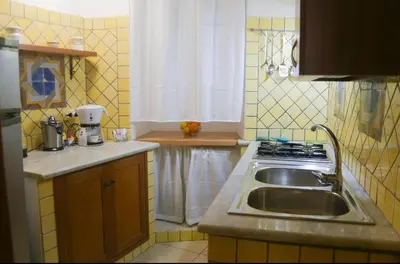 a kitchen with a sink and a stove at Sole Apartment in Palermo