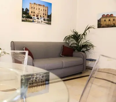 a living room with a couch and a glass table at Sole Apartment in Palermo