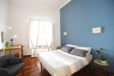 a bedroom with a large bed and a blue wall at iFlat Key House tra il centro e il mare in Palermo
