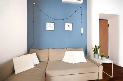 a couch in a living room with a blue wall at iFlat Key House tra il centro e il mare in Palermo
