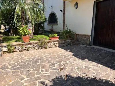 a house with a stone walkway in front of a door at IL Rustico di Giò in Carini