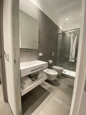 a bathroom with a sink and a toilet and a mirror at IL DUCA HOUSE e HOLIDAY PRESTIGE in Caccamo