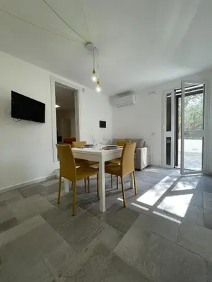 a dining room with a white table and chairs at Marosa Casa Vacanze in Torretta
