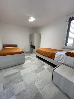 a bedroom with two beds and a tiled floor at Marosa Casa Vacanze in Torretta