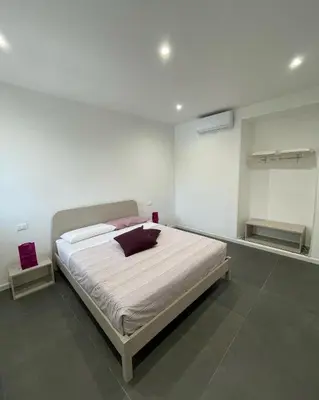 a bedroom with a large bed with white sheets at Marosa Casa Vacanze in Torretta