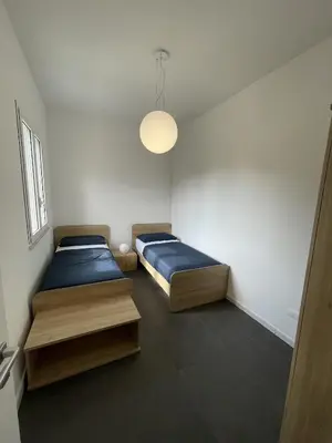 a bedroom with two beds and a light fixture at Marosa Casa Vacanze in Torretta