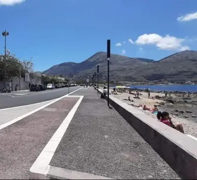 a road with people sitting on the beach at Domus Rosaliae - Casa Vacanze in Palermo