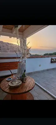three women in robes sitting in chairs on a roof at il tramonto in Capaci