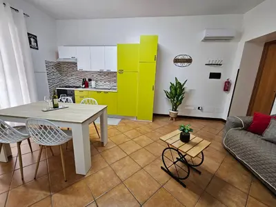 a kitchen and a living room with a table and chairs at LA CASA DI VIOLA in Palermo