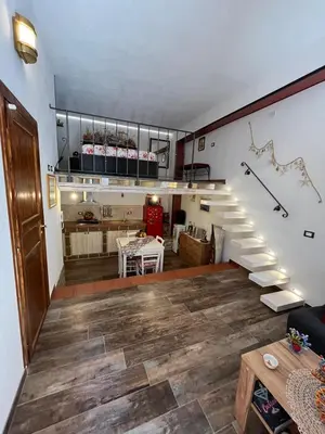 a living room with a staircase and a table at Al Vicoletto Boutique in Castellammare del Golfo