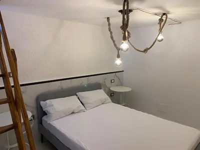 a bedroom with a white bed with aendant light at Al Vicoletto Boutique in Castellammare del Golfo