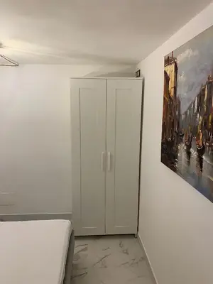 a bedroom with a white cabinet and a painting at Al Vicoletto Boutique in Castellammare del Golfo