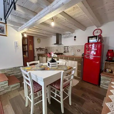 a kitchen with a white table and a red refrigerator at Al Vicoletto Boutique in Castellammare del Golfo