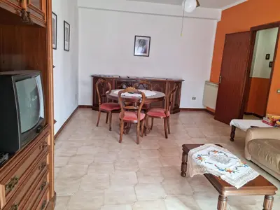 a living room with a table and a tv at Casa di Mamma in Godrano