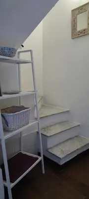a white staircase in a room with a shelf at Le Casette in Palermo
