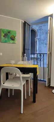 a dining room with a table and chairs and a window at Le Casette in Palermo