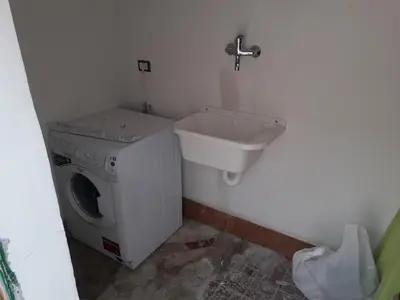 a bathroom with a washing machine and a sink at VILLA CHIARA 200 MT DA MARE SPIAGGIA LIBERA SABBIA in Capaci