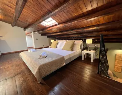 a bedroom with a large bed in a room with wooden ceilings at Domus Conte Federico in Palermo