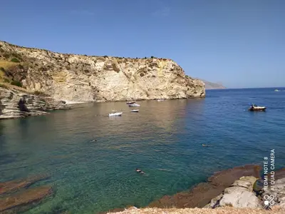 a group of boats in the water next to a cliff at CasaAntonietta in Alcamo