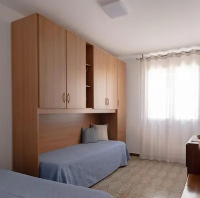 a bedroom with a bed and wooden cabinets at CasaAntonietta in Alcamo