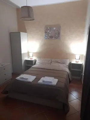 a bedroom with a bed with two night stands and two lamps at La Cycas in Trabia