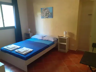 a bedroom with a blue bed with towels on it at La Cycas in Trabia