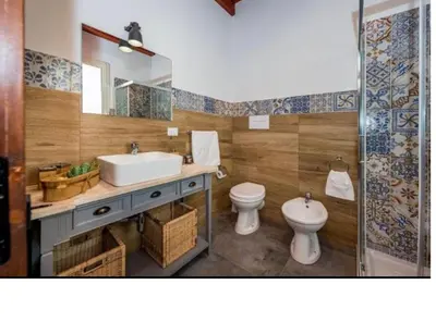 a bathroom with a sink and a toilet and a mirror at Villa Mirò in Castellammare del Golfo